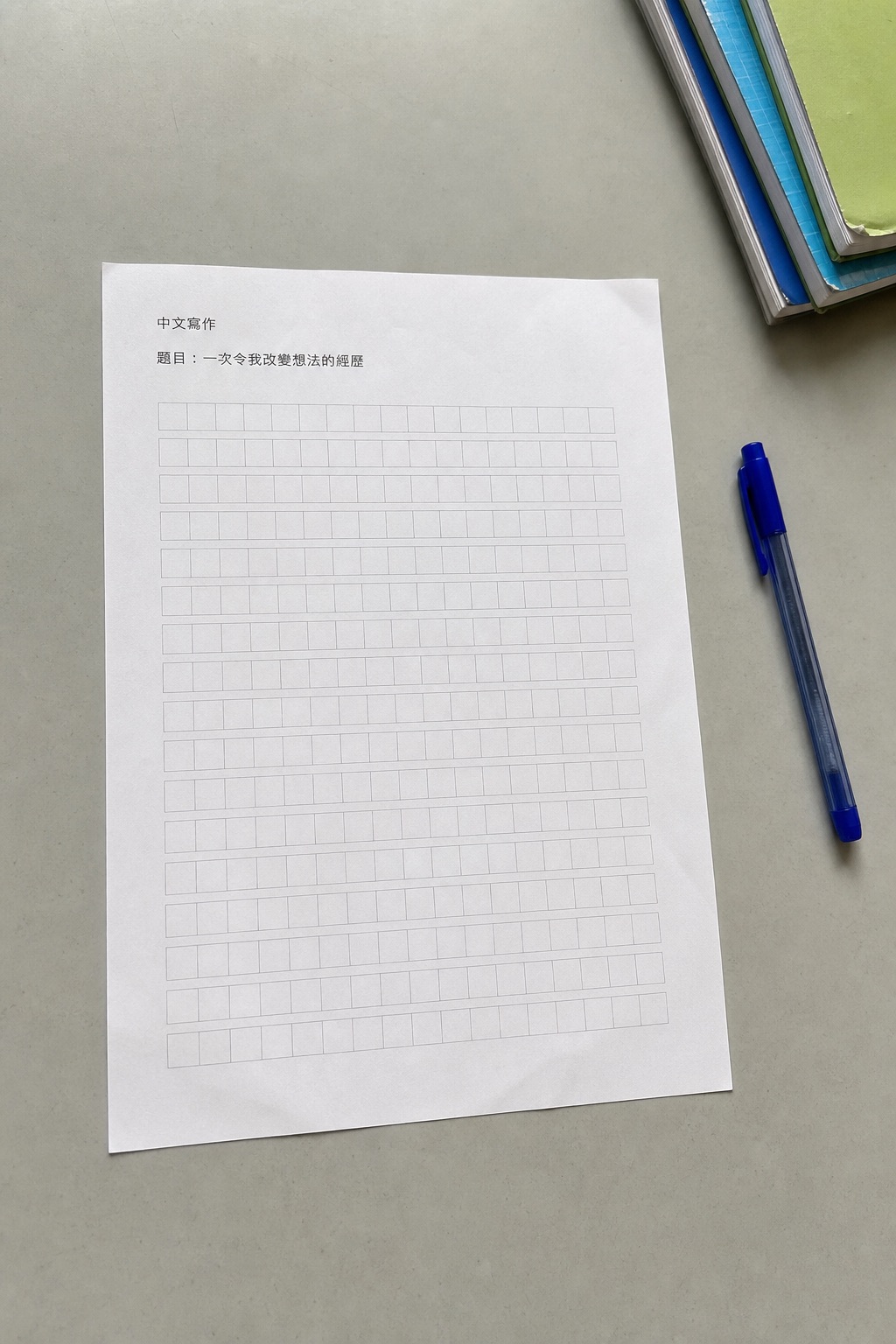 灰色桌面上一張完整拍攝的繁體中文作文紙,題目很小並留有大量方格寫作空間